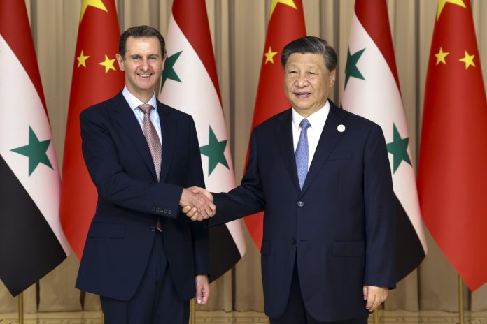 Chinese President Xi Jinping shakes hands with Syria's President Bashar al-Assad in eastern Hangzhou city